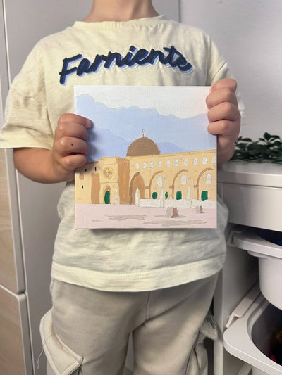 Un enfant tient la mosquée du Prophète qu’il a peinte