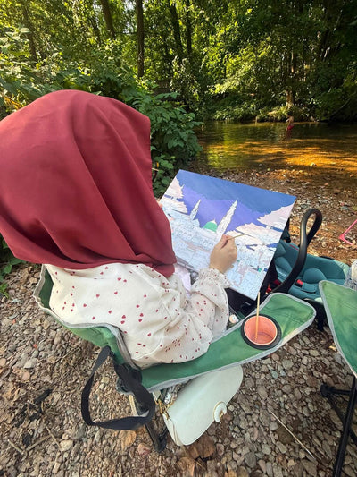 Une enfant peint la mosquée du Prophète au bord d’une rivière