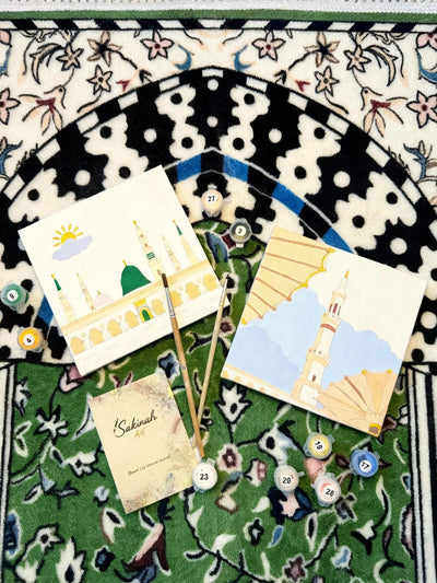 Deux tableaux d’un coffret enfant en cours, posés sur un tapis de prière
